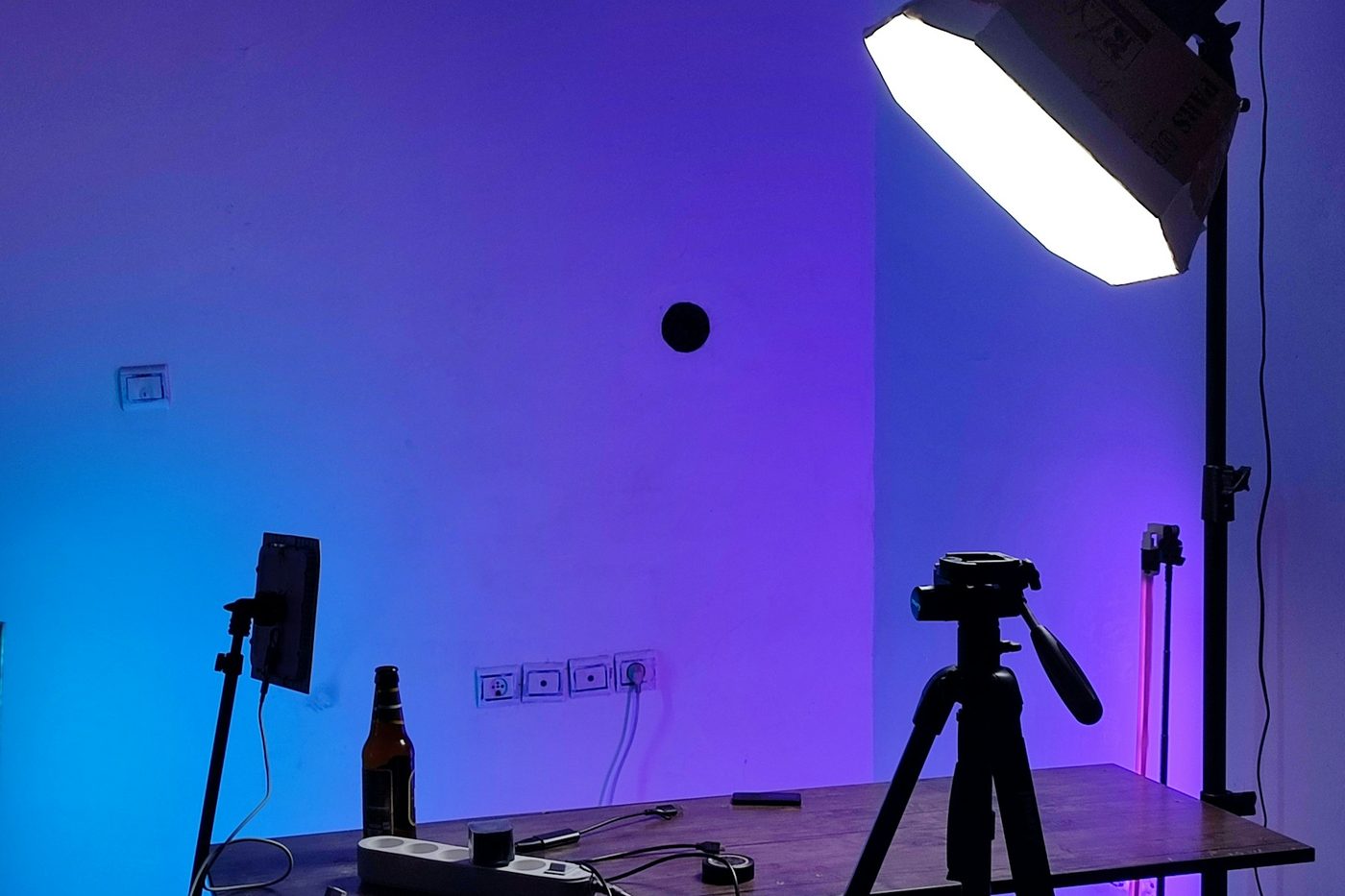 Panneau LED et trépied installés dans un studio aux murs colorés